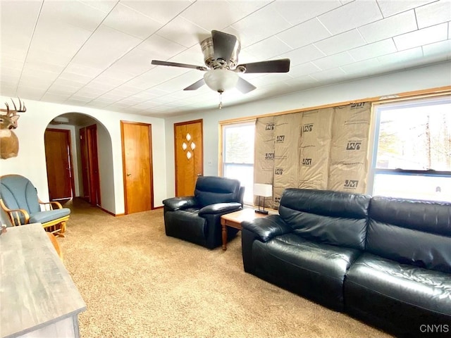 carpeted living room featuring ceiling fan and a wealth of natural light