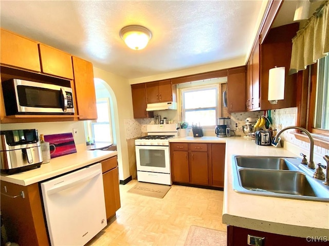 kitchen with tasteful backsplash, sink, and white appliances