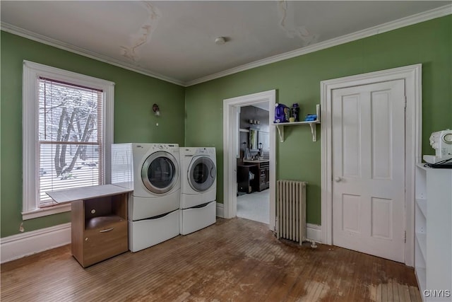 laundry area featuring hardwood / wood-style flooring, crown molding, radiator, and independent washer and dryer