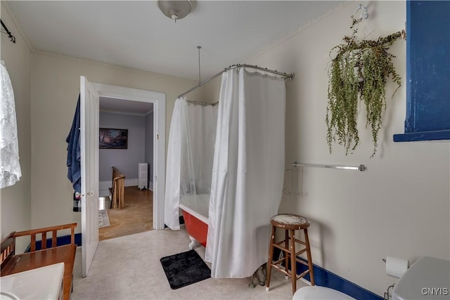 bathroom featuring shower / bathtub combination with curtain, ornamental molding, and toilet