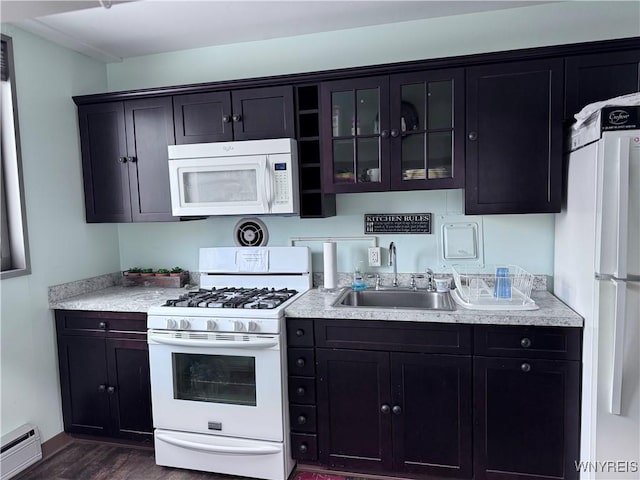 kitchen with dark wood-type flooring, sink, dark brown cabinets, white appliances, and a baseboard heating unit