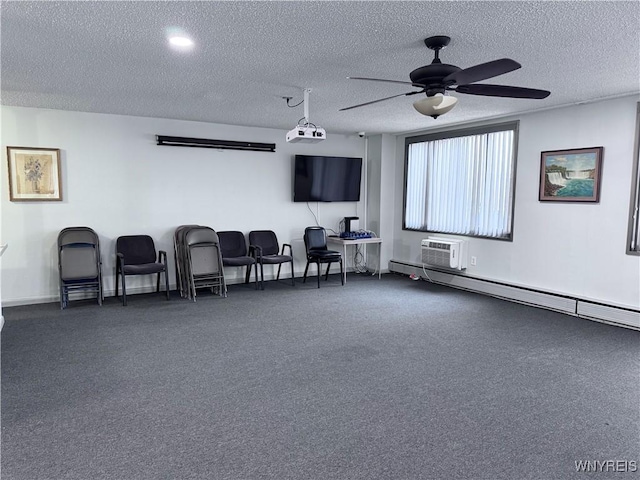 cinema room featuring a textured ceiling, a baseboard radiator, an AC wall unit, and ceiling fan