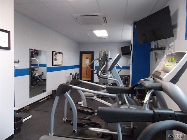 gym with a paneled ceiling