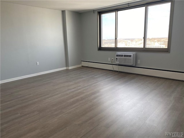 empty room featuring a baseboard heating unit, dark hardwood / wood-style floors, and a wall mounted AC