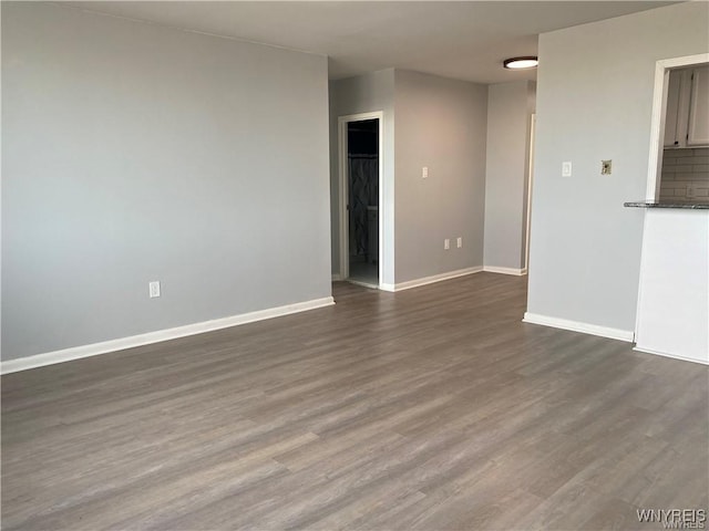 unfurnished living room with dark wood-type flooring