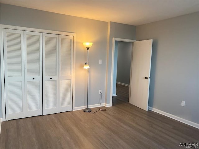 unfurnished bedroom featuring dark hardwood / wood-style flooring and a closet