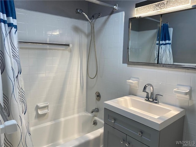 bathroom with vanity, tile walls, shower / bath combination with curtain, and decorative backsplash