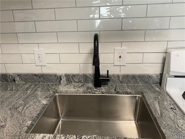 room details with dark stone countertops, sink, and decorative backsplash