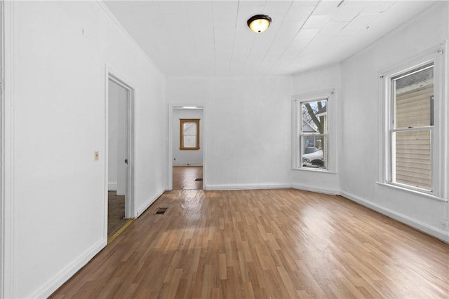 empty room featuring crown molding and hardwood / wood-style flooring