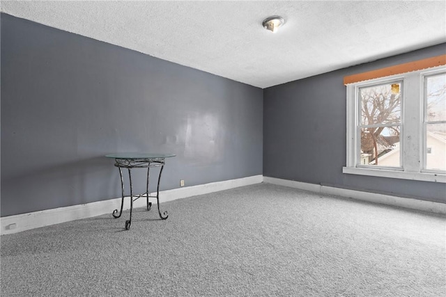 carpeted spare room featuring a textured ceiling