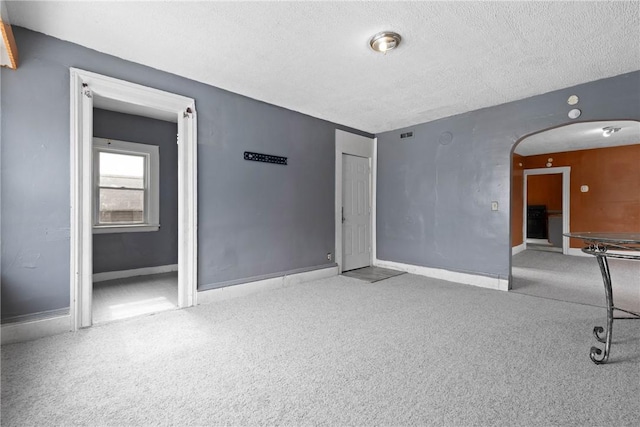 carpeted spare room with a textured ceiling