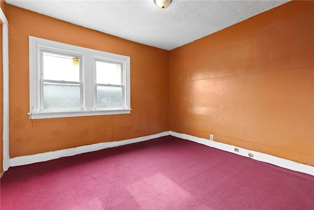 carpeted empty room with a textured ceiling