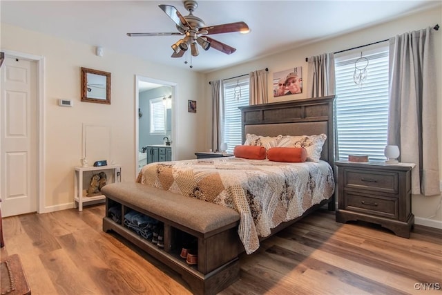 bedroom featuring hardwood / wood-style floors, ceiling fan, and ensuite bathroom