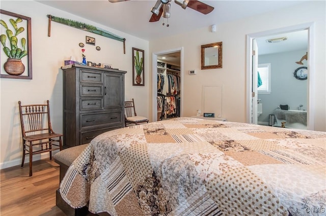 bedroom with a walk in closet, wood-type flooring, and a closet