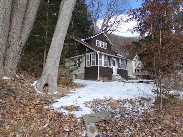 view of snowy exterior with a sunroom