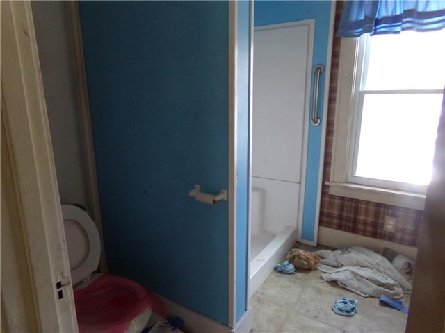 bathroom with a shower, tile patterned floors, and toilet