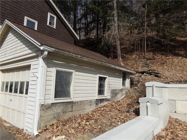 view of property exterior with a shingled roof
