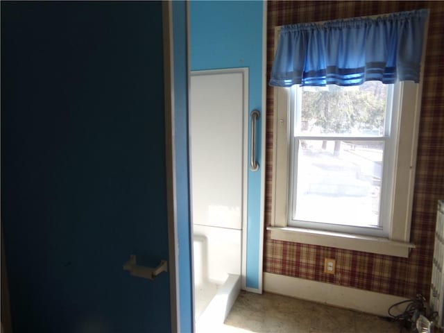 bathroom featuring wallpapered walls and baseboards