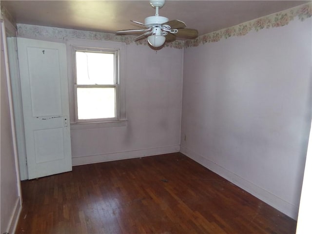spare room featuring dark wood-style floors, baseboards, and ceiling fan
