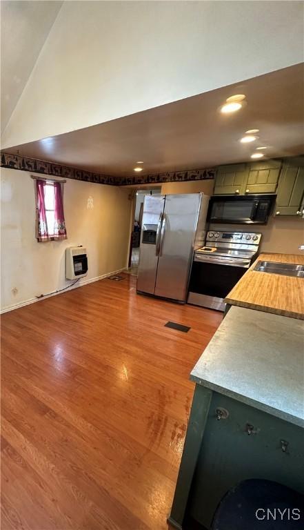 32458 County Route 54, Clayton, NY 13632 - kitchen featuring sink, heating unit, green cabinets, stainless steel appliances, and light hardwood / wood-style floors