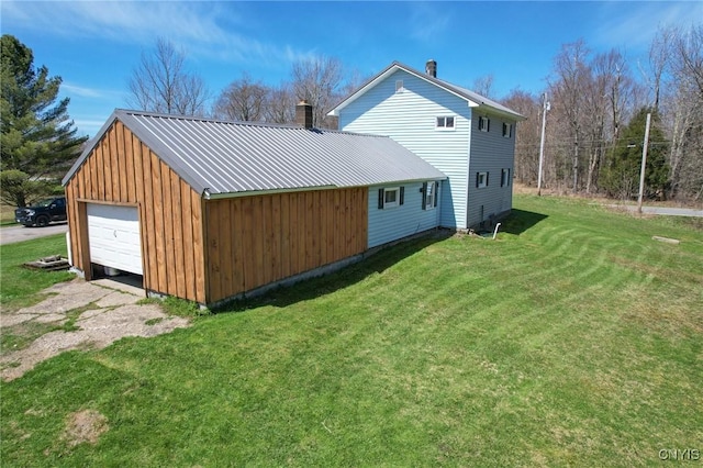 view of property exterior with a garage, a lawn, and an outdoor structure