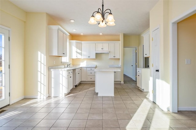 kitchen with hanging light fixtures, white cabinetry, a kitchen island, and plenty of natural light