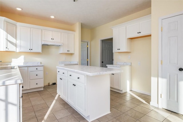 kitchen featuring light tile patterned floors, sink, white cabinets, and a kitchen island