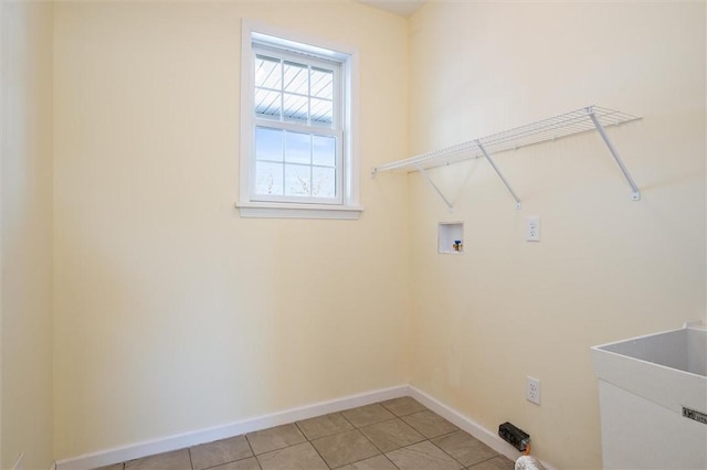 washroom with washer hookup, sink, and light tile patterned floors