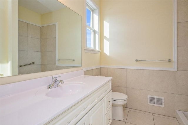 bathroom with tile patterned floors, toilet, tile walls, and vanity