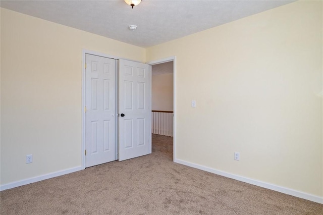 unfurnished bedroom with a closet and light carpet