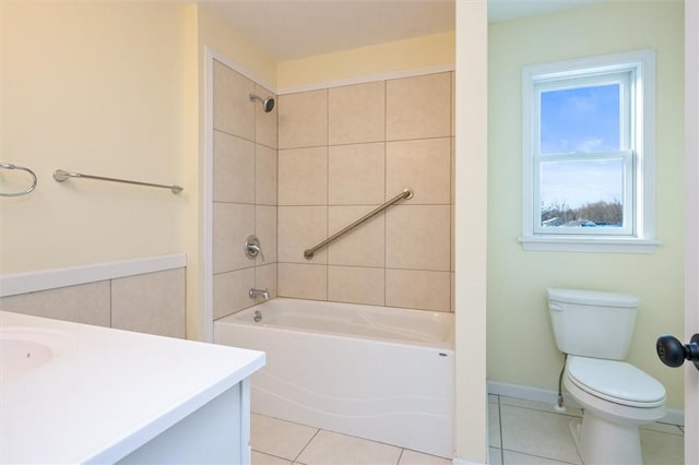 full bathroom with tile patterned flooring, vanity, tiled shower / bath, and toilet