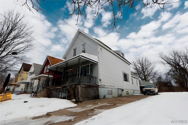 snow covered property featuring a porch