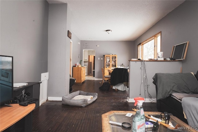 living room with dark wood-type flooring and a textured ceiling