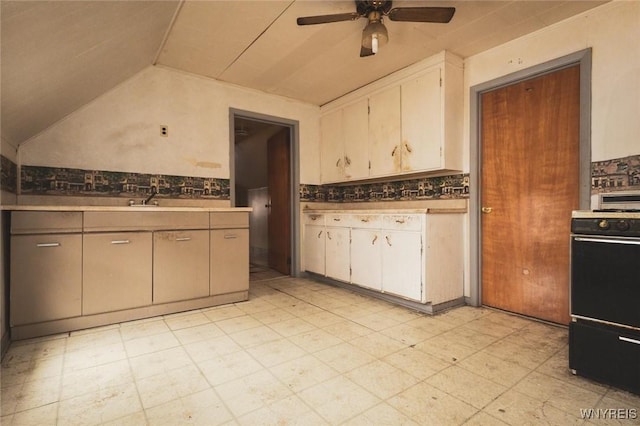 kitchen with ceiling fan, vaulted ceiling, decorative backsplash, and stove