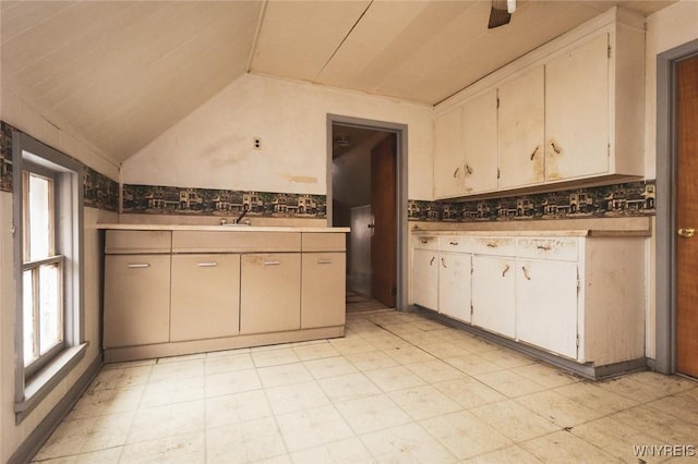 kitchen featuring tasteful backsplash, sink, and vaulted ceiling