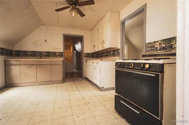 kitchen featuring tasteful backsplash, gas range, vaulted ceiling, and ceiling fan