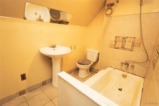 bathroom featuring lofted ceiling, a tub, sink, toilet, and tile patterned floors