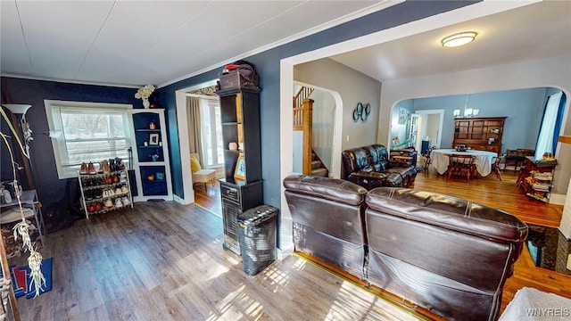 living room featuring a notable chandelier, crown molding, and wood-type flooring