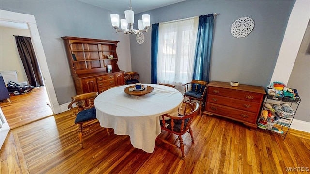 dining room with hardwood / wood-style floors and a notable chandelier