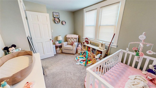 bedroom featuring a nursery area and carpet flooring