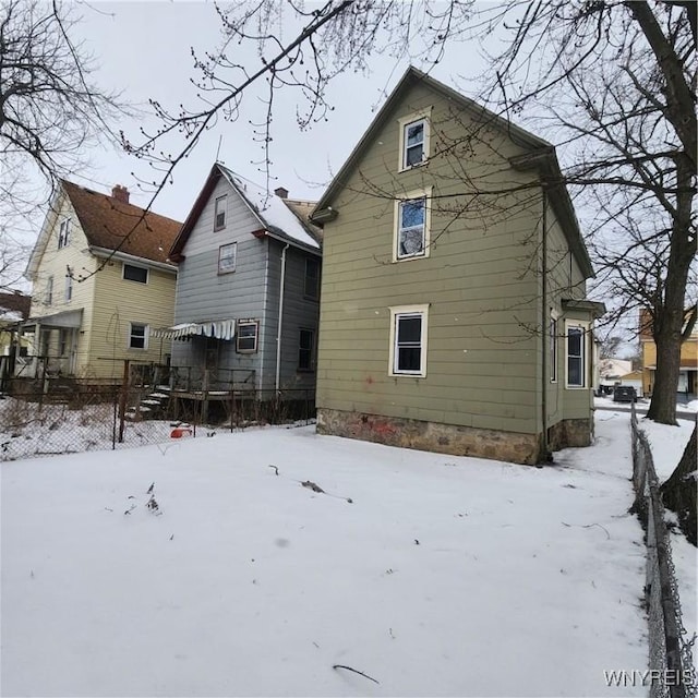 view of snow covered rear of property