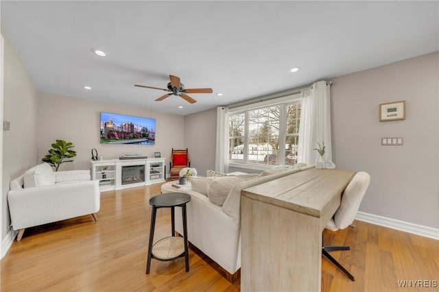 living room featuring ceiling fan and light hardwood / wood-style flooring