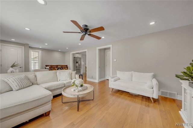 living room featuring ceiling fan and light hardwood / wood-style flooring