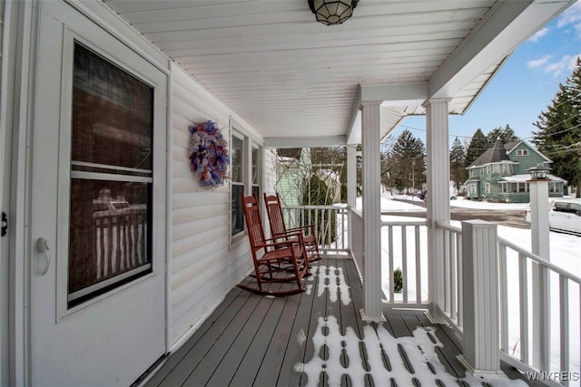 snow covered deck with a porch