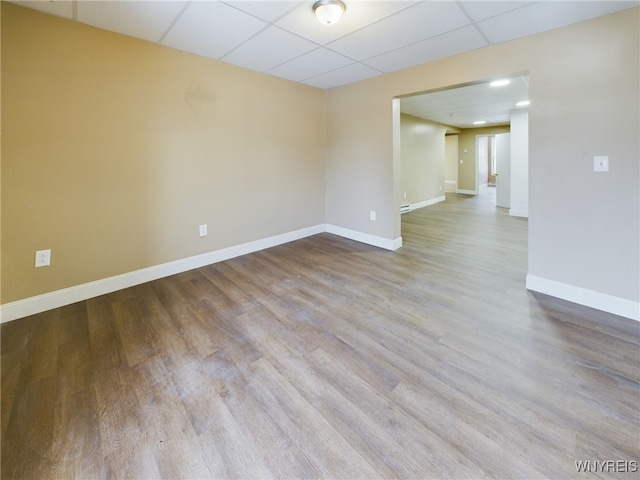 spare room featuring a paneled ceiling and light wood-type flooring