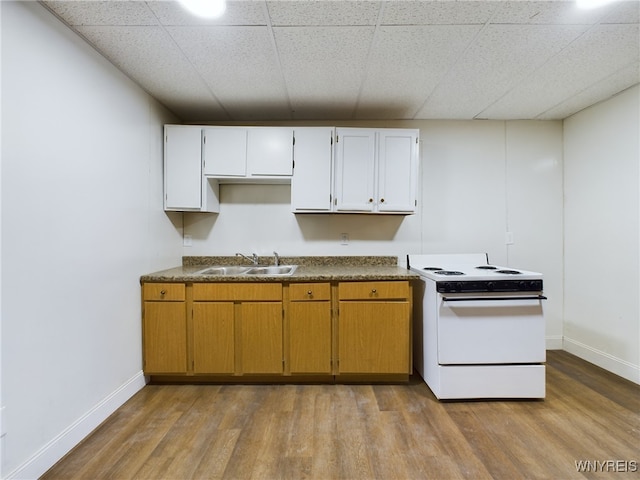 kitchen with a paneled ceiling, white electric range, sink, white cabinets, and light wood-type flooring