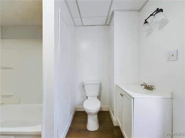 bathroom featuring hardwood / wood-style flooring, a paneled ceiling, vanity, and toilet