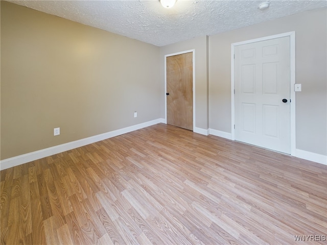 unfurnished bedroom featuring a textured ceiling, light hardwood / wood-style floors, and a closet