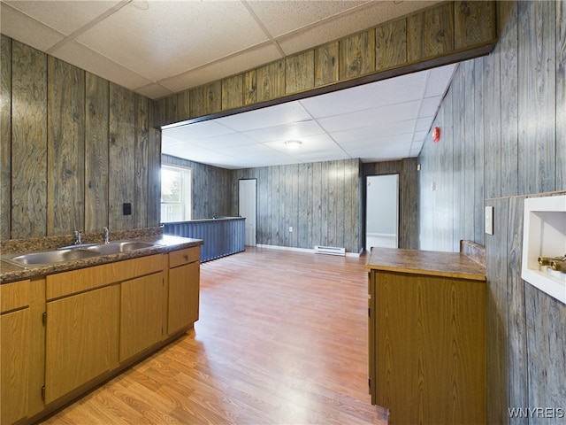 kitchen featuring a paneled ceiling, a baseboard radiator, sink, and light wood-type flooring