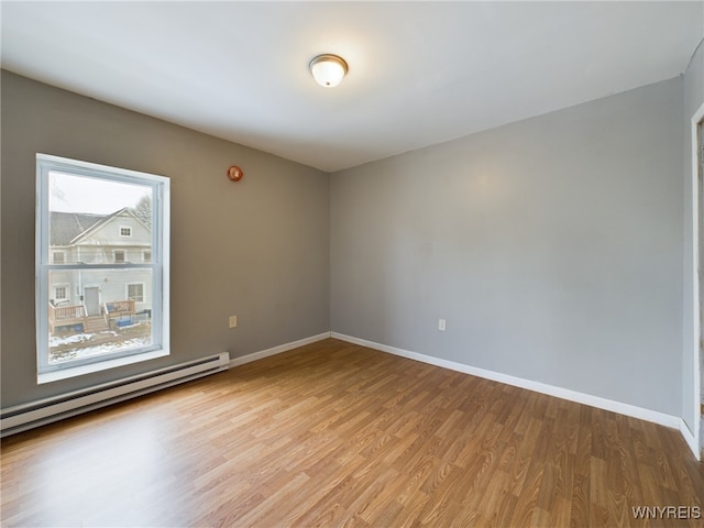 unfurnished room with light wood-type flooring and baseboard heating